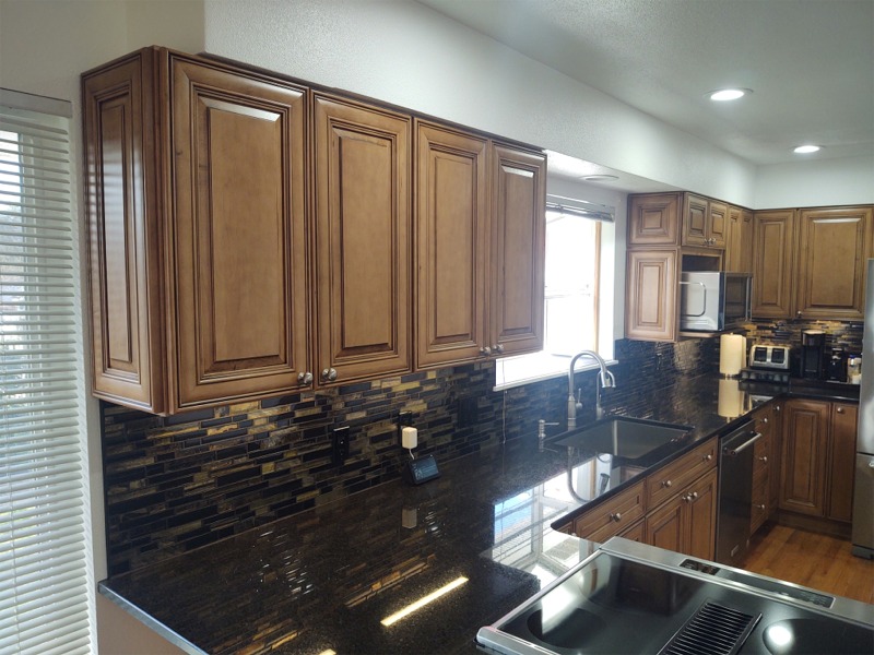 Granite kitchen island countertop, with convection cooktop and tile backsplash